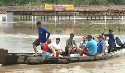 Moradores ficam ilhados e precisam usar canoas para atravessar rio após passagem alagar com chuvas, na PB